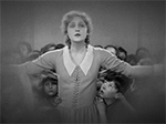 Maria approaches the camera with arms outstretched, children crowding behind her