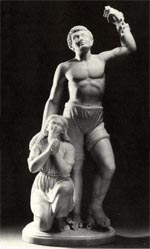 A black and white photograph of a stone sculpture of a man standing looking upwards and a single hand raised, and a woman bent on a knee with both hands clasped in prayer. Both faces have expressions of deep gratitude.